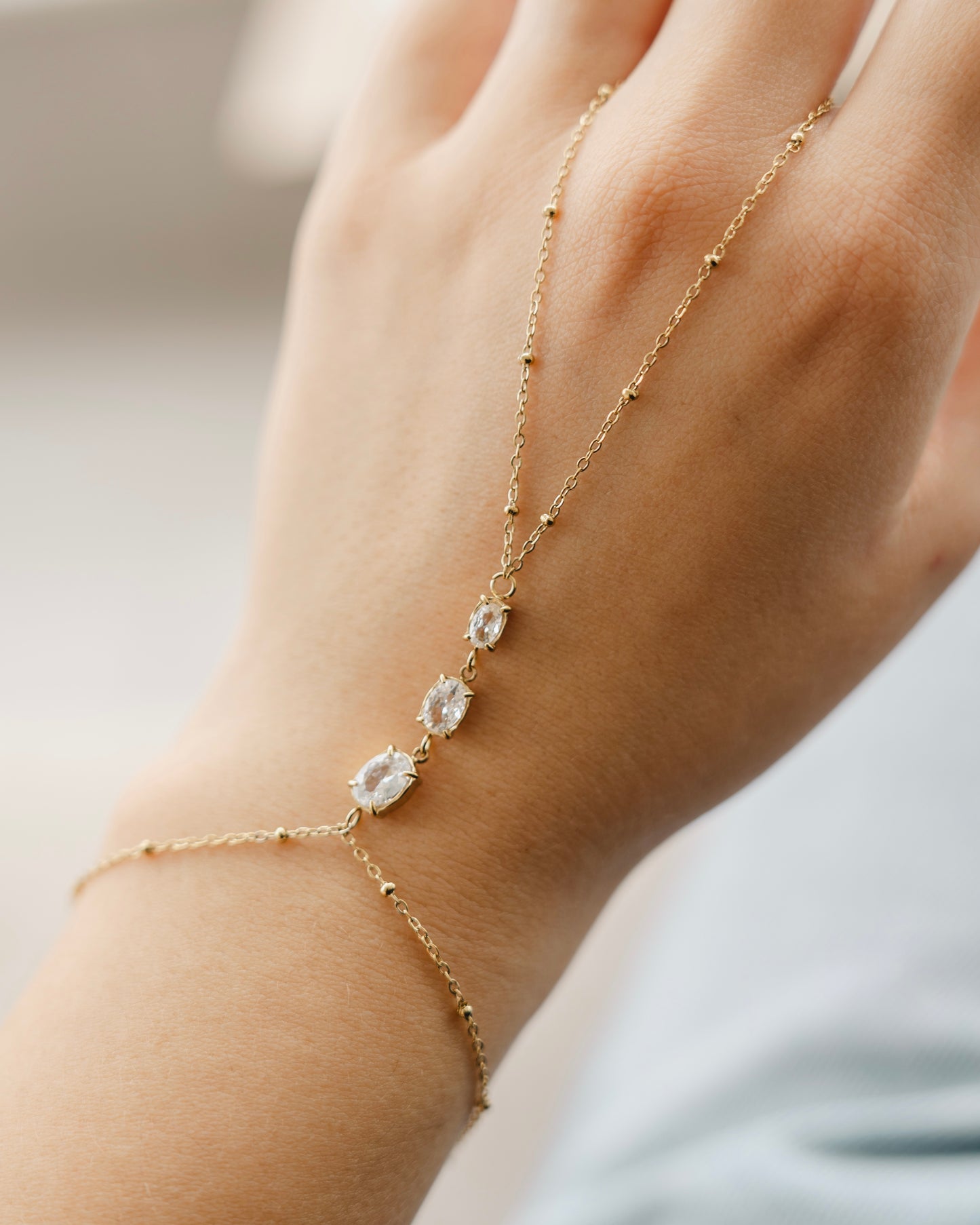 White oval stone Hand chain gold